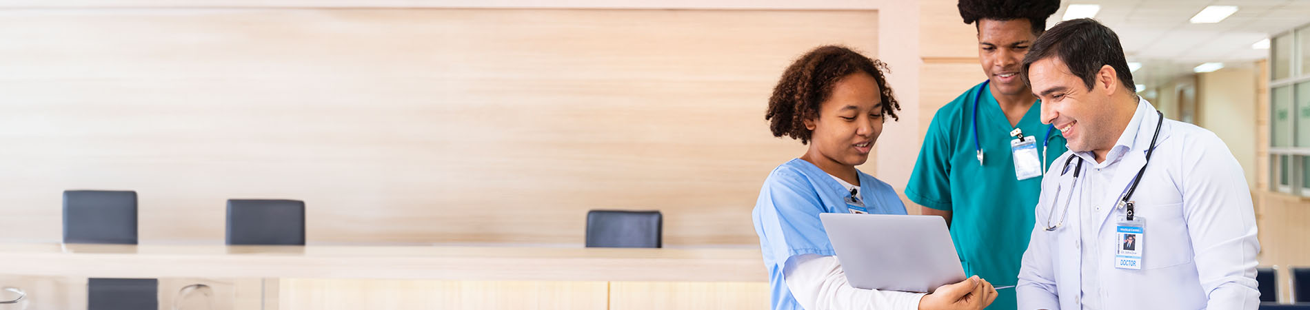 group of health care providers looking at tablet in office